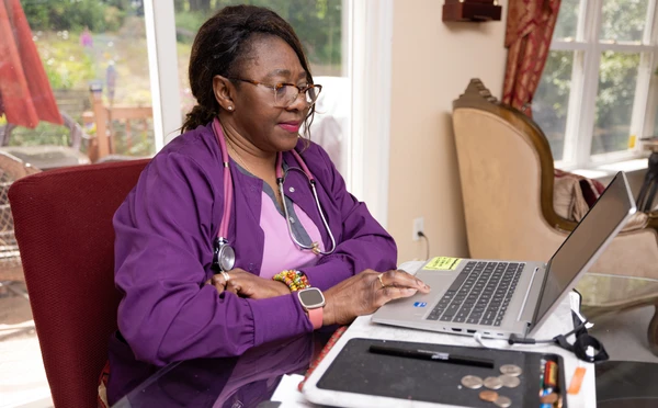 nursing student types on computer in their home