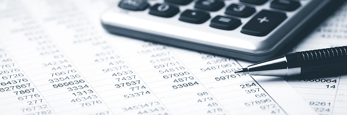 photo of spreadsheet, pen, and calculator