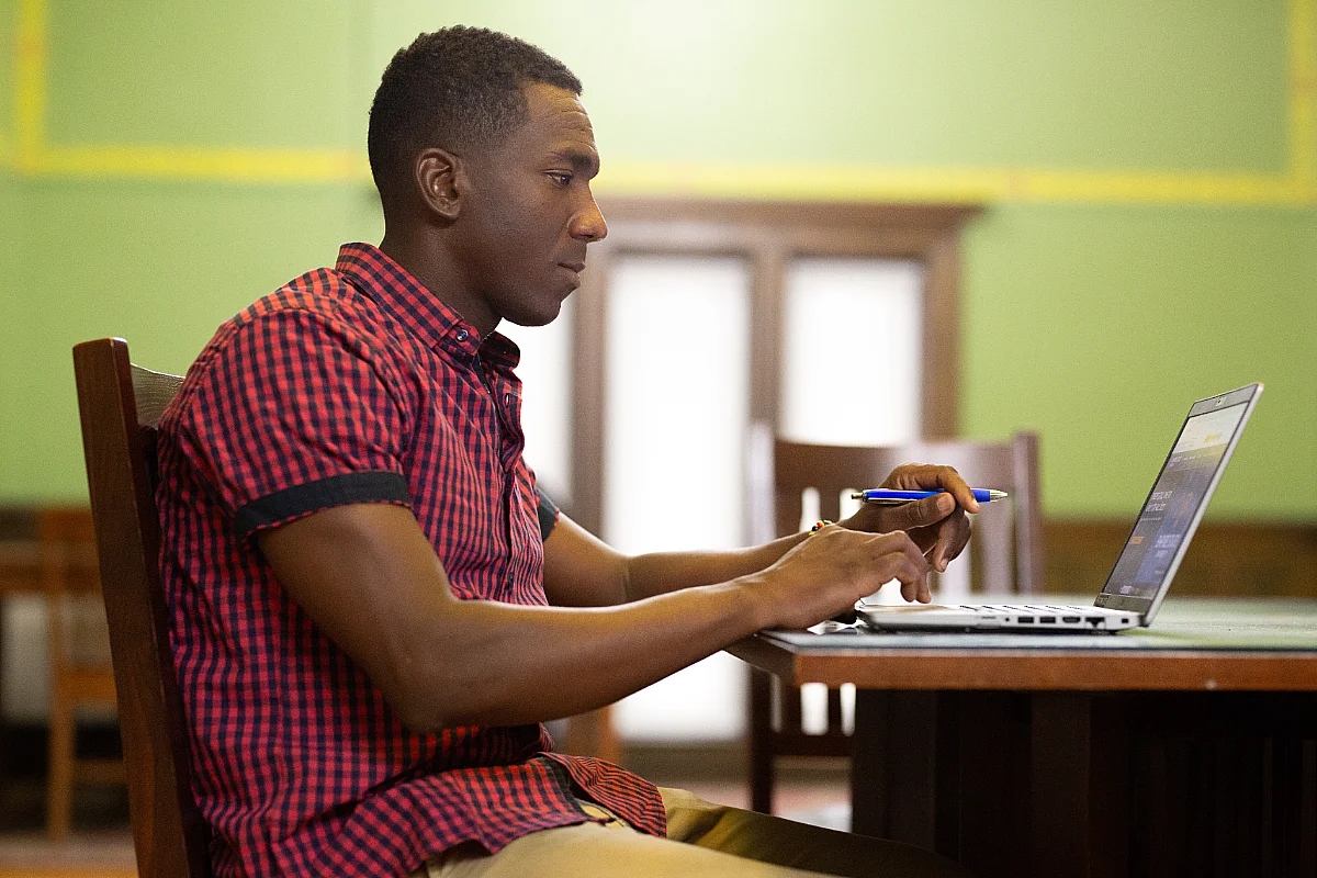student sits in front of laptop in library