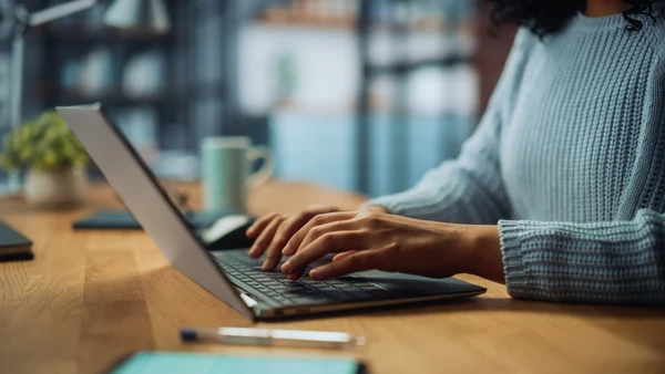 close-up photo of somebody typing on laptop