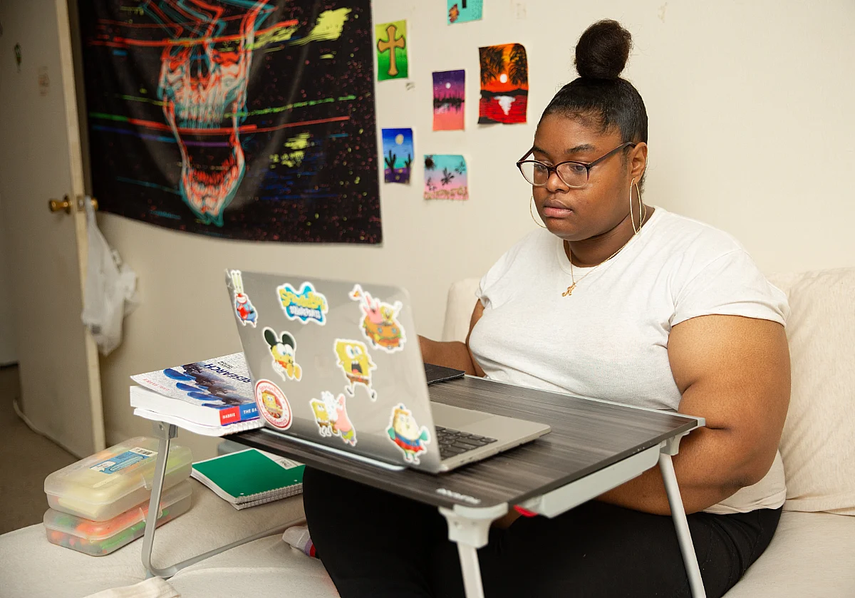 A woman sits at her laptop.