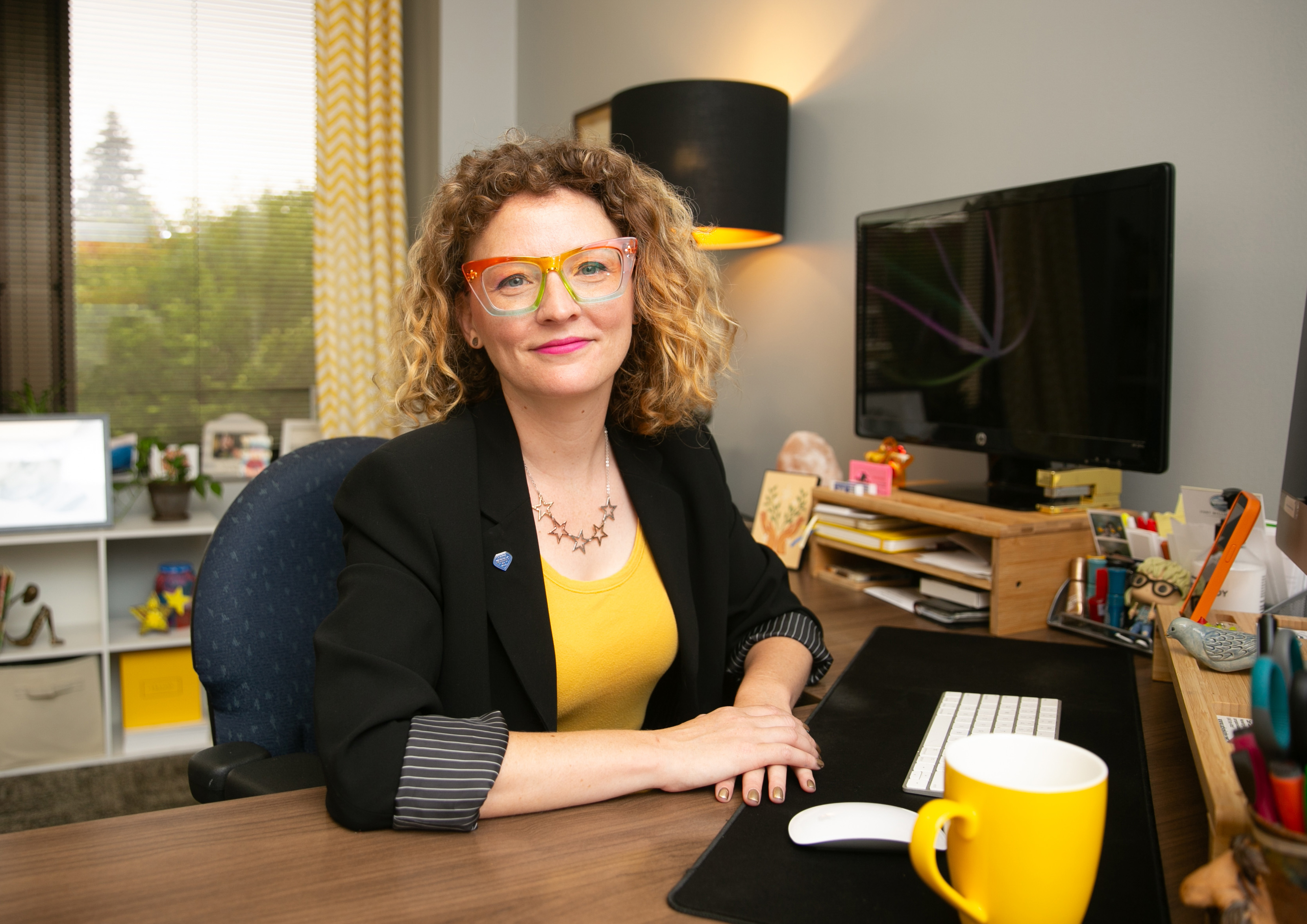 Woman sits at an office desk.