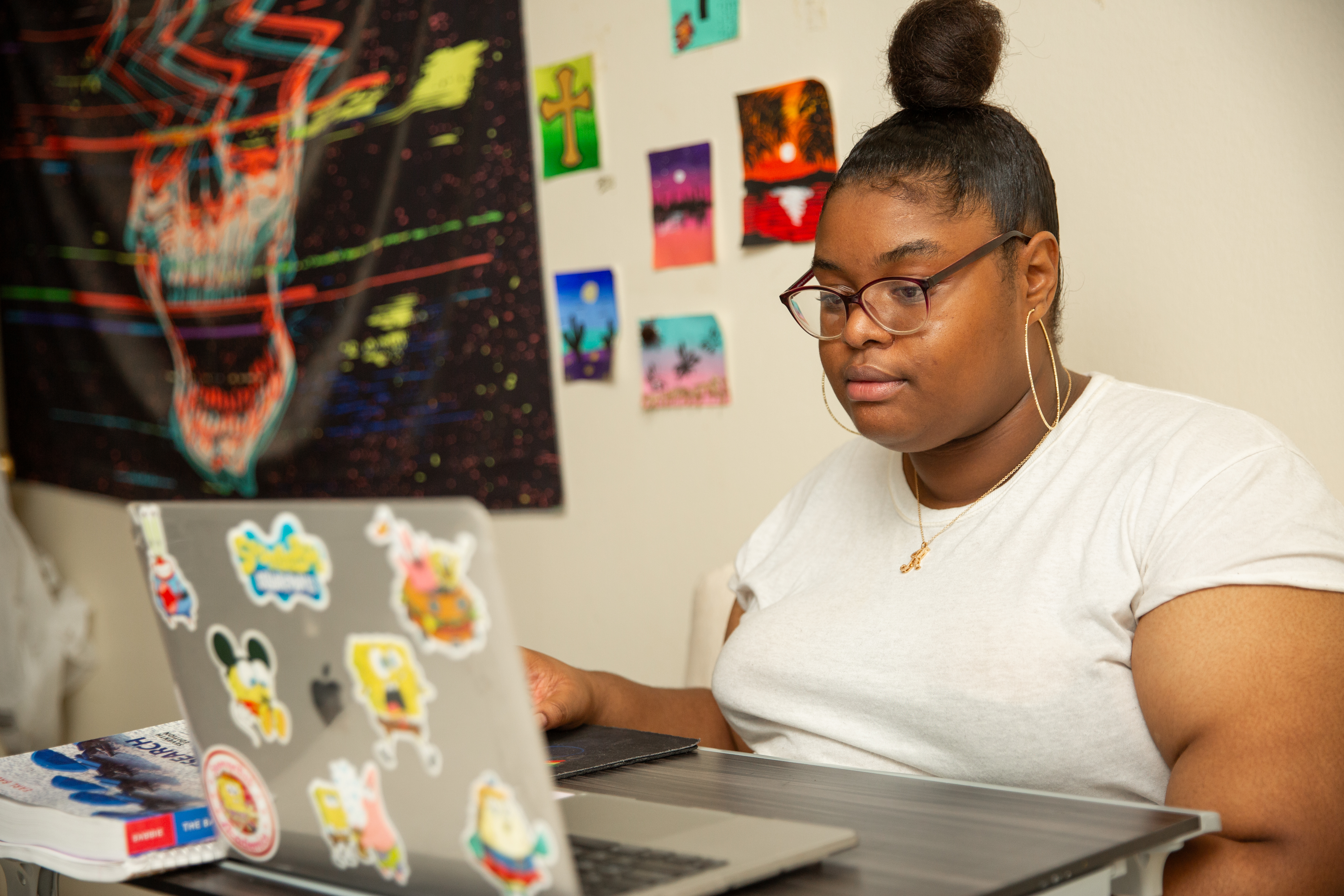 A woman sits at her laptop.