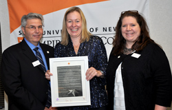 Northeast Center Dean Gerry Lorentz and Acting President Meg Benke, center, present Director of Academic Support Lisa D’Adamo-Weinstein, at right, with the Chancellor’s Award for Excellence in Professional Service.