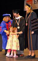 Master’s recipient Michael DeMasi of Clifton Park, is joined on stage by his daughters as Tai Arnold, acting dean of the School for Graduate Studies, left and Acting President Meg Benke, right, look on.