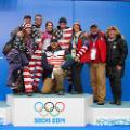 Erin Hamlin '11 surrounded by her parents, brothers and friend. Her coach, two-time Olympic medalist and USA Luge program director Mark Grimmett, kneels in front.