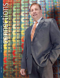 Mike Russo ’10, director of government relations for the semi-conductor manufacturer, GlobalFoundries, is pictured in front of a chip disc display - cover of Connections Fall 2012